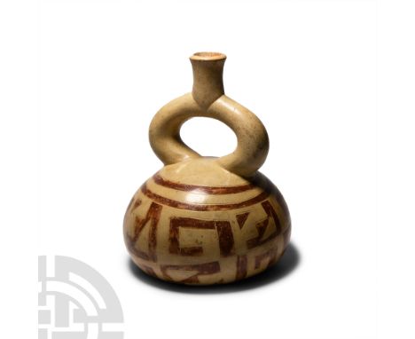 2nd-5th century A.D. A bichrome ceramic stirrup vessel composed of a squat, domed body decorated with geometric motifs.  709 