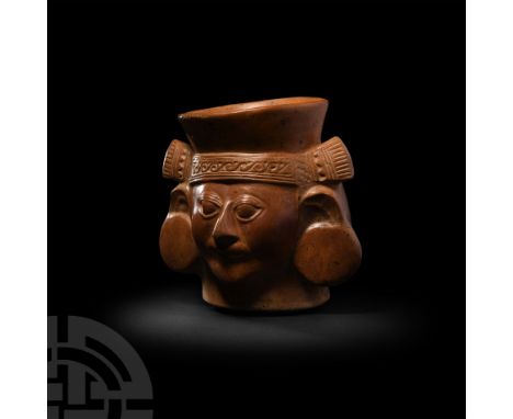 Circa 3rd-6th century A.D. A ceramic cup in the form of a male head, modelled wearing a headdress with geometric decoration a