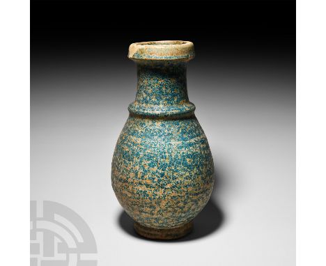 2nd-3rd century A.D. A piriform blue-glazed ceramic jar with convex collar and splayed foot, bituminous coating to the interi