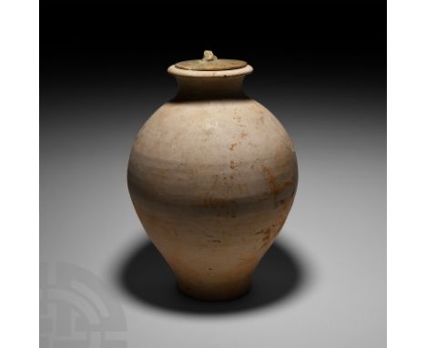 Tang/Song Dynasty, 618-1279 A.D. An ovoid whiteware ceramic jar with subtly splayed base; glazed discoid lid with separately 