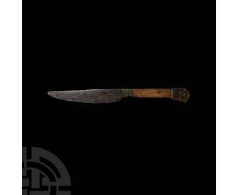 15th-16th century A.D. A scale-tanged iron knife with one cutting edge and wood scales, bifacial brass pommel with incised de