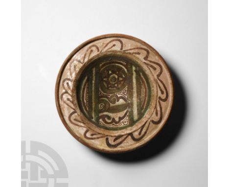 Circa 15th century A.D. A ceramic bowl with a shallow body and broad flange rim with raised lip, geometric scheme to interior