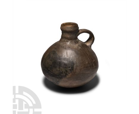 15th-17th century A.D. A black ware bottle with bulbous body, cylindrical neck with inverted rim and strap handle; possibly C