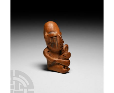 2nd century B.C.-3rd century A.D. A polychrome ceramic figure formed as a mother figure cradling an infant, the mother in a s