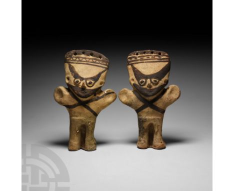 10th-14th century A.D. A pair of ceramic figures, each modelled standing with stub arms outstretched, wearing pierced headdre