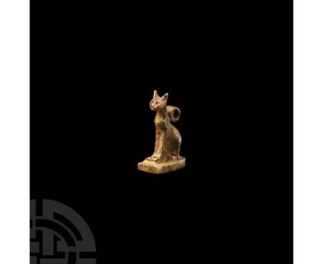 Third Intermediate Period, 1069-702 B.C. A gold amuletic pendant in the form of a cat sitting on a tongue-shaped base, and as