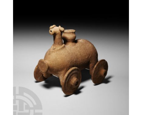 Late 2nd-1st millennium B.C. A roughly capsule-shaped ceramic rhyton formed as a bull or ram with four wheels, pot-shaped ves