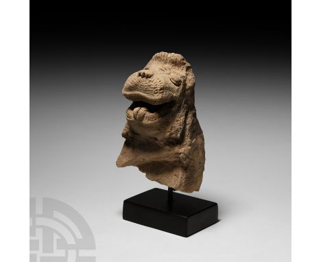 Early 1st millennium B.C. A ceramic figurine section, the head and upper body of a demon with thick ribbed skin, broad head w