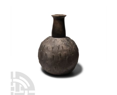 9th-2nd century B.C. A black ware Chavin vase in the form of a gourd with long neck and mottled surface featuring small creat