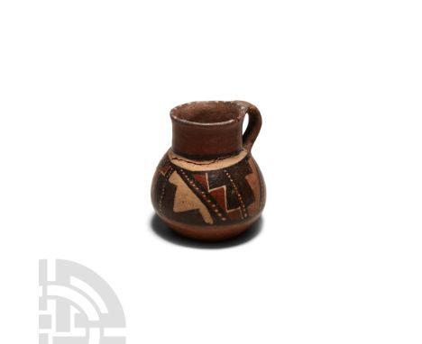 2nd-5th century A.D. A ceramic jug with integral handle and carinated body, the upper half decorated with a polychrome stairw