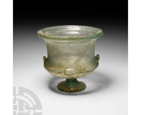 Circa 5th-3rd century B.C. A green glass krater with two applied handles and splayed foot; areas of iridescence.  394 grams, 