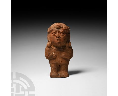 Circa 3rd-5th century A.D. A ceramic fertility figure modelled as a female standing facing, hands clasping breasts, wearing a