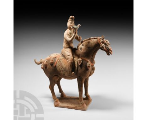 Tang Dynasty, 618-907 A.D. A ceramic horse and mounted hunter figure modelled in the round, standing on an integral rectangul