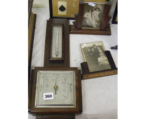 An oak wall barometer/thermometer and two oak picture frames.