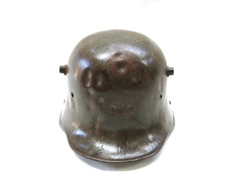 A WWI German M1916 helmet with majority of leather liner intact, impact dents to front 