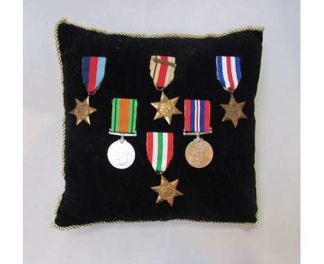 A cushion with six WWII medals including Africa star with 8th Army clasp