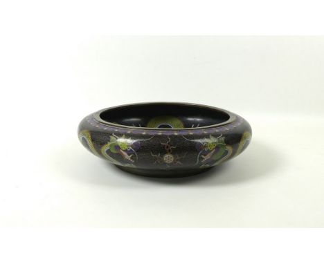 A Chinese cloisonne bowl, likely Qing dynasty, the black clouded ground decorated with Imperial yellow five toed dragons chas