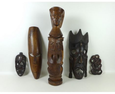 A mid 20th century Fijian carved figure with three faces, 65cm tall, a Maori hardwood mask, a Maori Tiki mask and further har