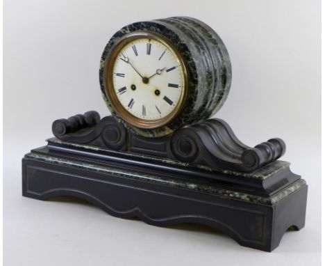 A Victorian green marble and slate mantle clock, the white enamel dial with Roman numerals, the drum shaped body on scrolling