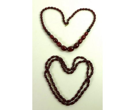A vintage string of cherry amber coloured beads of graduated size, the largest measuring approximately 24.6cm, the smallest 1