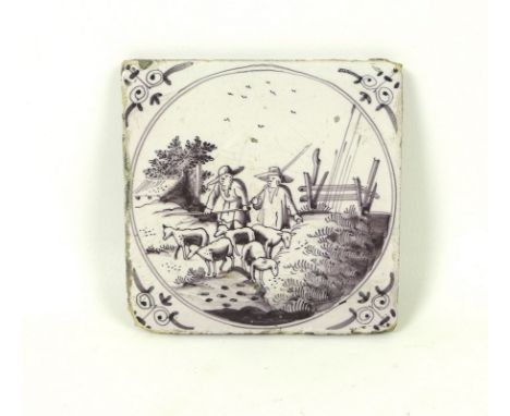 An 18th century Delftware manganese tile, 12.6 by 12.6cm, the circular reserve painted with two shepherds and their flock, to