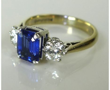 A sapphire and diamond ring, the central royal blue emerald cut sapphire of approximately 1.5ct, 7.45 by 5.92mm, depth approx