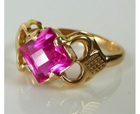 A Continental 14ct gold ring with vibrant pink princess cut ruby of approximately 6.59 by 6.6mm in unusual setting, marked to