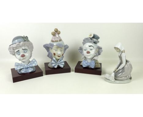 A collection of Lladro clown busts, comprising numbers 5610, 5611 and 5612, complete with wooden stands, together with a Nao 