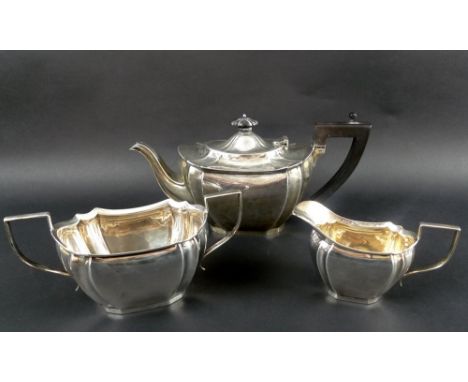 A George V three piece silver tea set, comprising teapot, milk jug and sucrier, all with boat shaped bodies with fluted detai