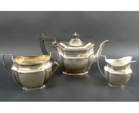 A George V three piece silver tea set, comprising teapot, milk jug and sucrier, all with reeded bands to faceted boat shaped 