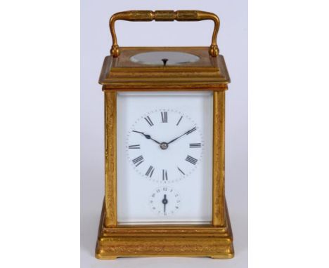 A carriage clock, with repeat, the 7 cm white enamel dial with Roman numerals and alarm, in a four pillar brass case, with en