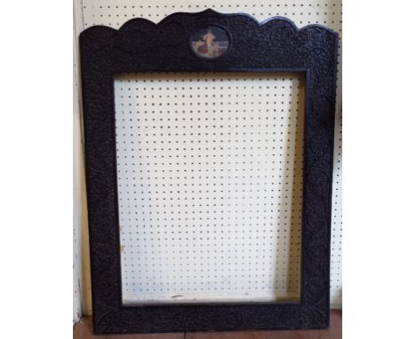 An Indian carved hardwood frame, the top rail inset and oval portrait, 79 cm high