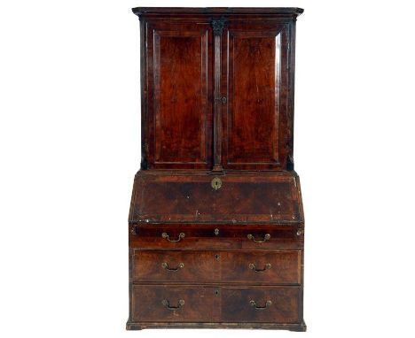 An 18th century bureau bookcase, veneered in walnut, the bookcase section having a pair of panel doors centred by a fluted Co