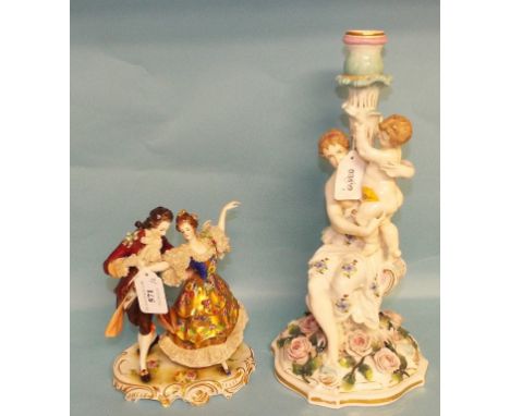 A Continental porcelain group, of two dancing figures, 19 cm high, and a figural porcelain candlestick (a.f.), 35 cm high (2)