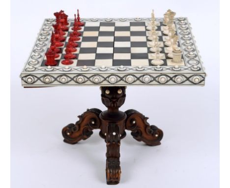 A Vizagapatam miniature tabletop chess table, on a carved tripod base, 19 cm square, with a natural and stained ivory chess s