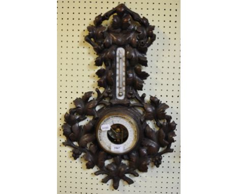 A Black Forest style barometer and thermometer, with carved decoration, 64 cm high
