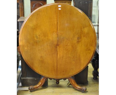 A Victorian walnut tilt top table, on a carved tripod base, 120 cm diameter