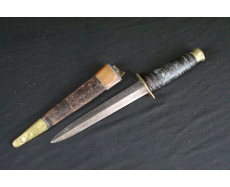 A vintage mid 20th century hunting / fighting knife, double edged blade, brass hilt, leather handle and brass pommel, blade l