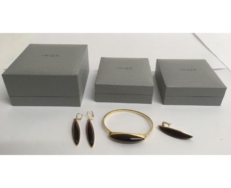 A Lalique glass jewellery set comprising red and gold coloured pendant drop, bangle and earrings, with conforming boxes