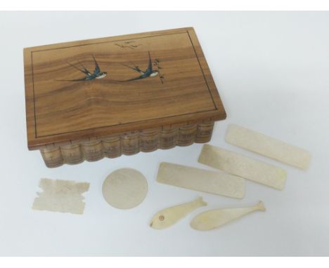 A book box with old mother of pearl gaming tokens with 1 other.