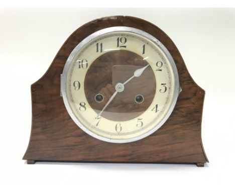 A mahogany mantel clock with Arabic numerals.