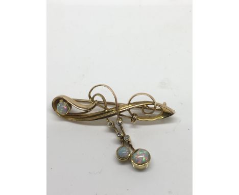 An Edwardian 15ct gold bar brooch set with opal and chip stone drops