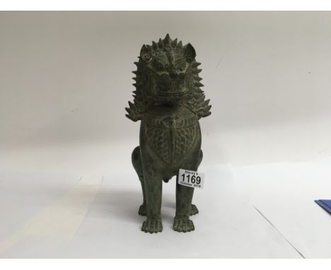 A  19 th century bronze temple lion of stylistic design 30 cm