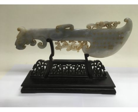 An early 20th Century jade ornament in the form of an archaic axe, inscribed with text believed to be poems. The jade itself 