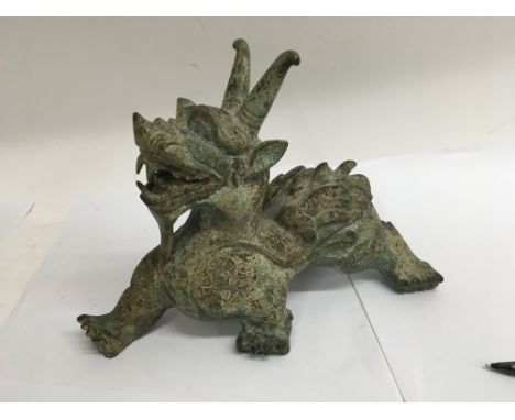 A 19 th century bronze temple lion with stylised decoration 21 cm