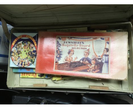 A travelling trunk containing various vintage board games and toys.