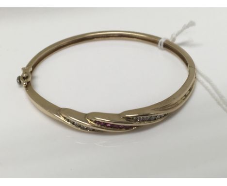 A 9 ct gold bangle inset with diamonds and Ruby’s 15 grams