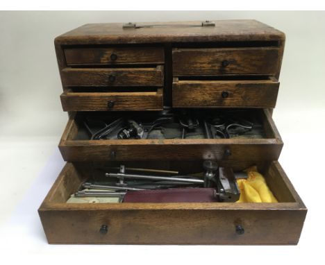 An oak fitted toolbox containing instruments and tools.