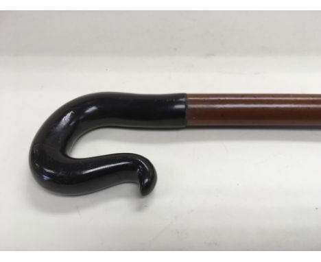 A walking stick with a possibly phenolic handle.