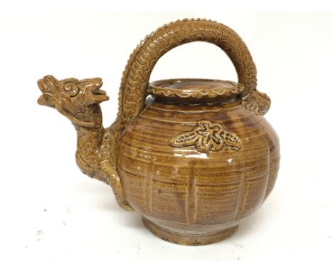 An unusual Chinese treacle glazed earthenware teapot in the form of a dragon, no marks to the base.